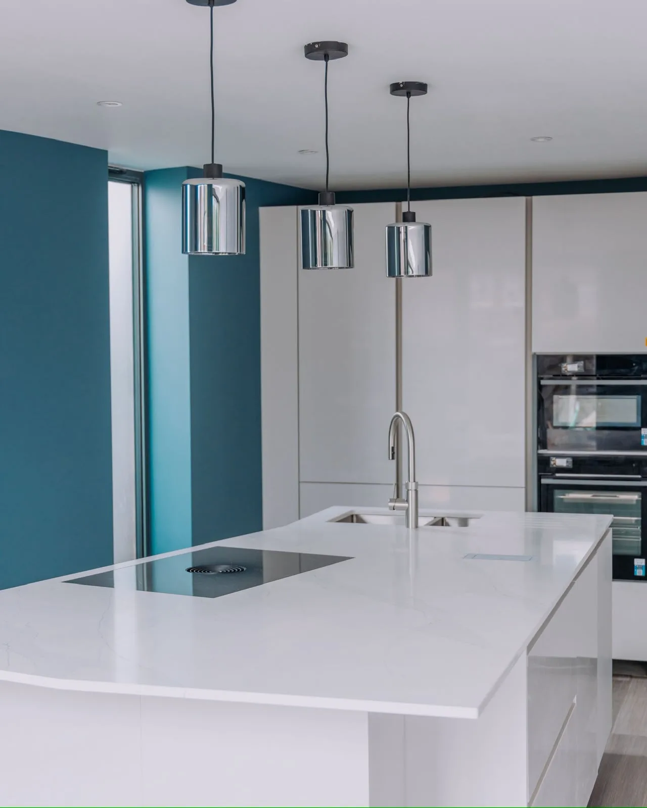 Modern kitchen with teal accent wall