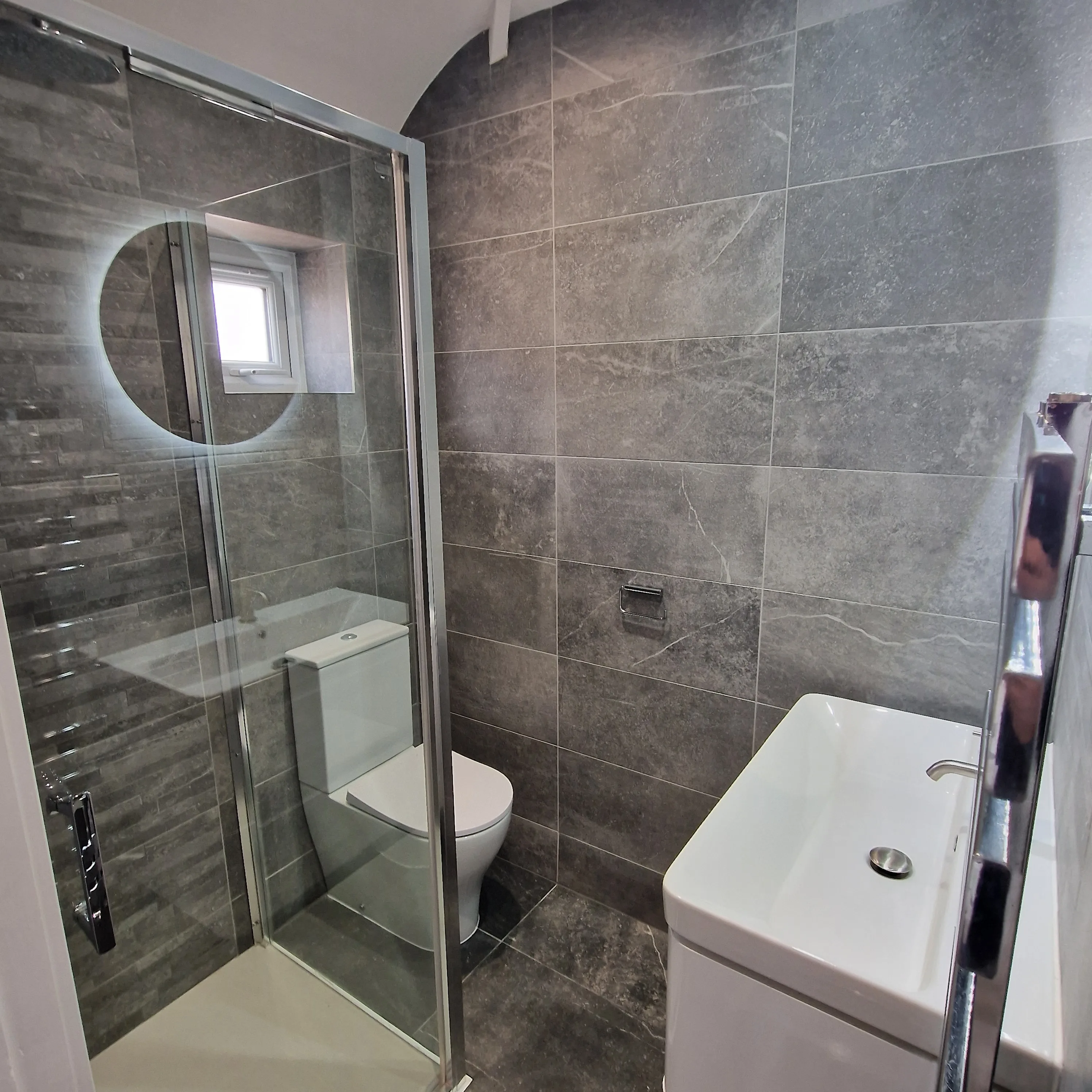 Modern bathroom featuring a glass shower enclosure and stylish tiles