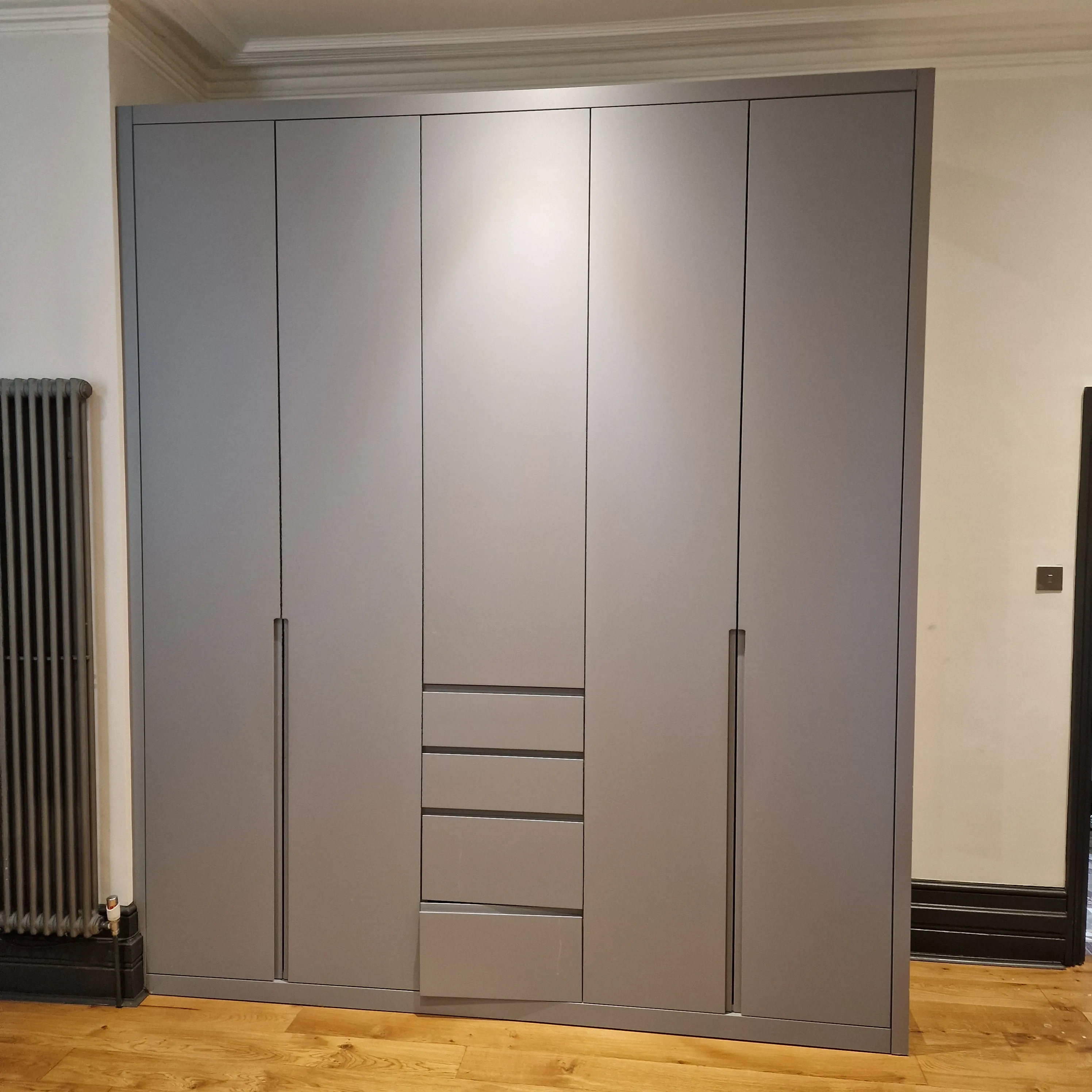 Modern bespoke wardrobe with sleek design and wooden flooring