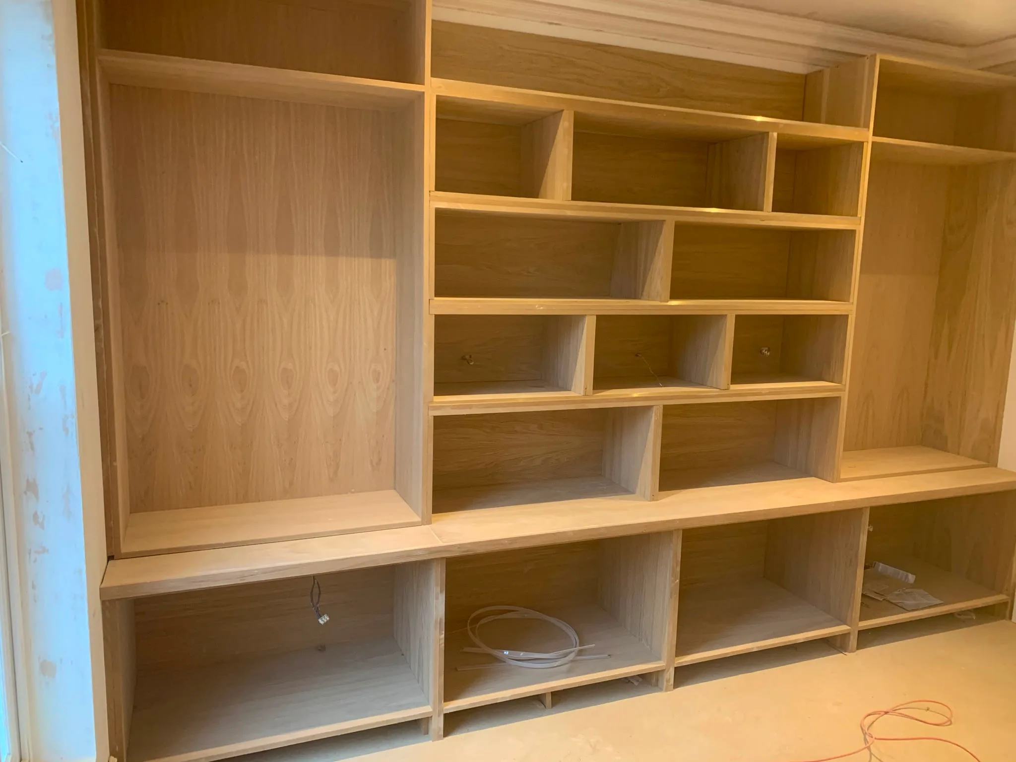 Wooden built-in wardrobe with open shelves and compartments in a room