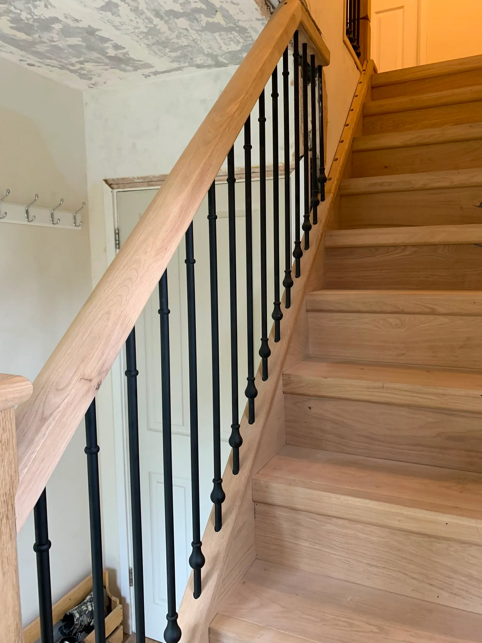 Wooden staircase with black metal railings showcasing interior carpentry work