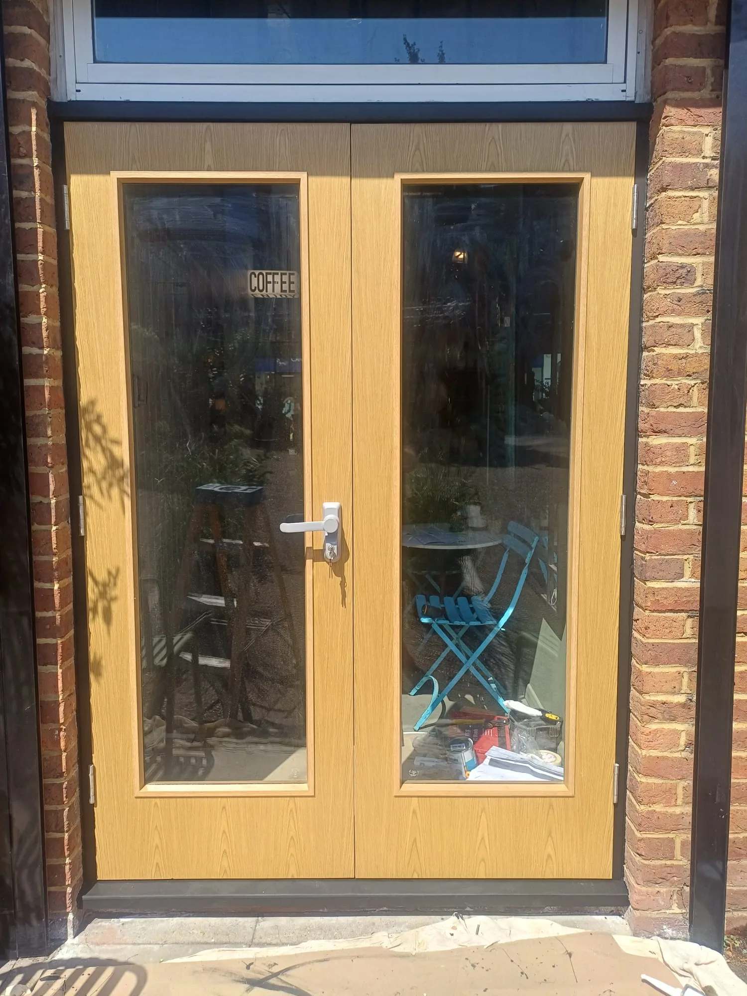 Wooden double doors with glass panels leading to an outdoor seating area