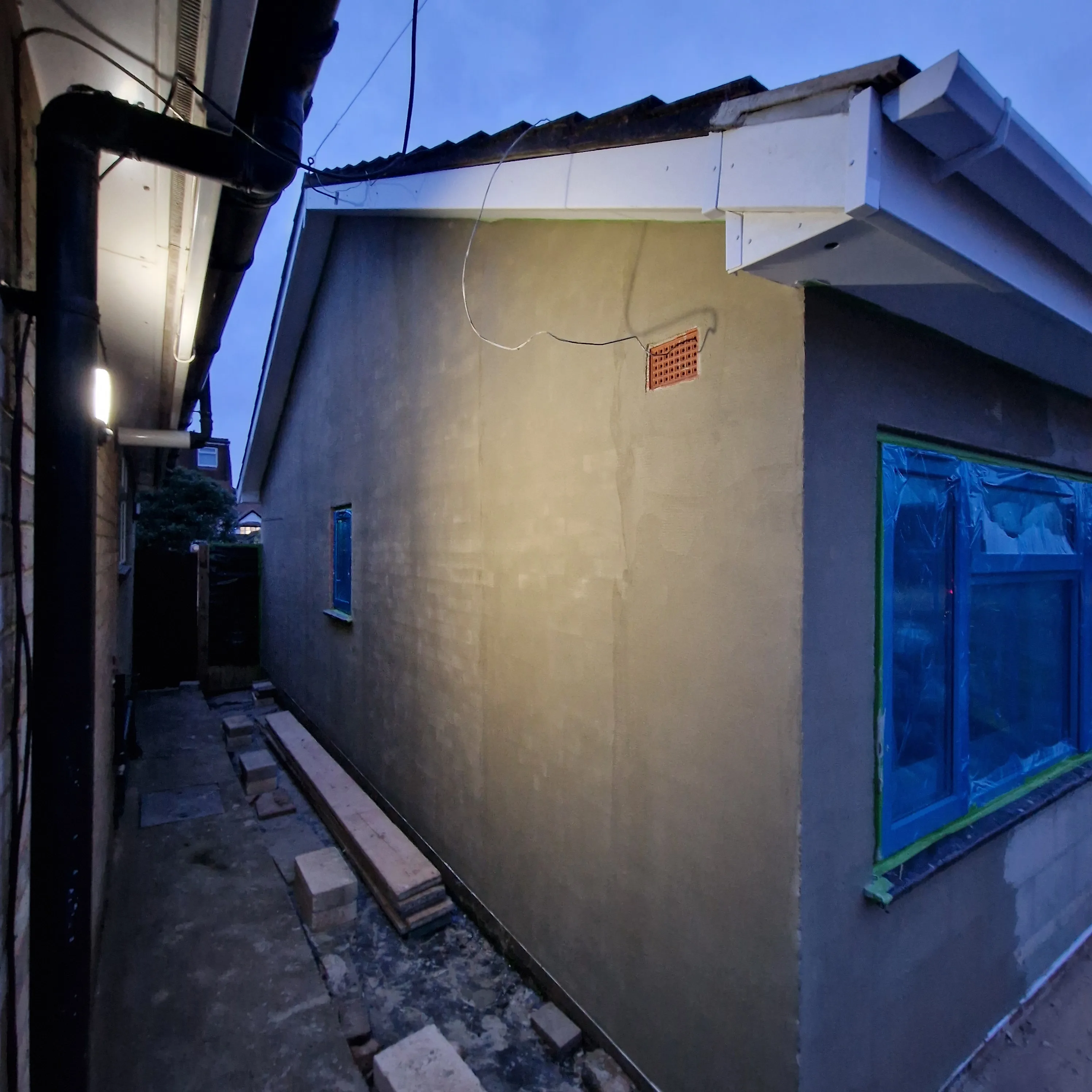 Exterior view of a house showing recent rendering and window installation
