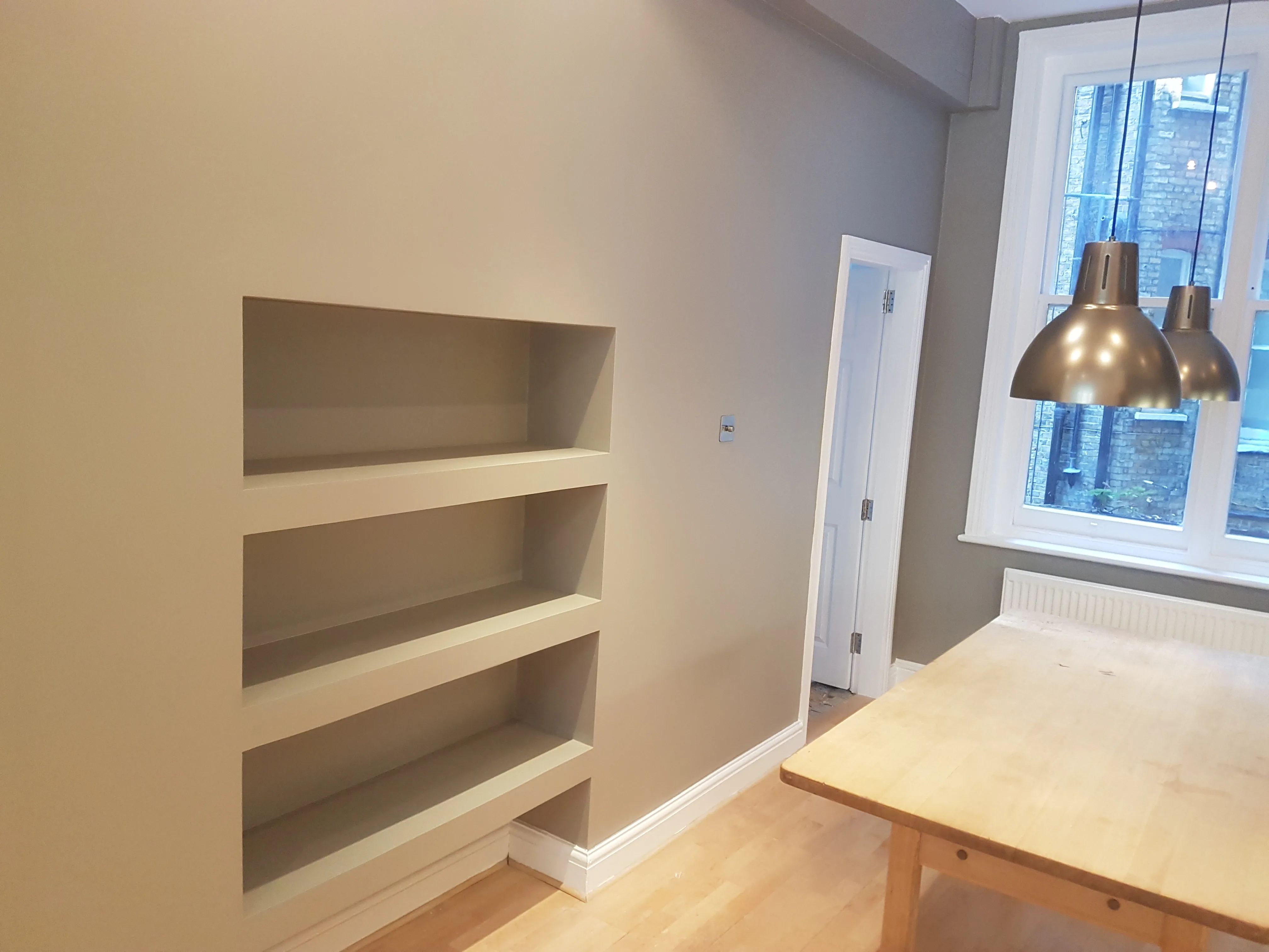 Modern interior featuring built-in shelves and pendant lighting in a dining area