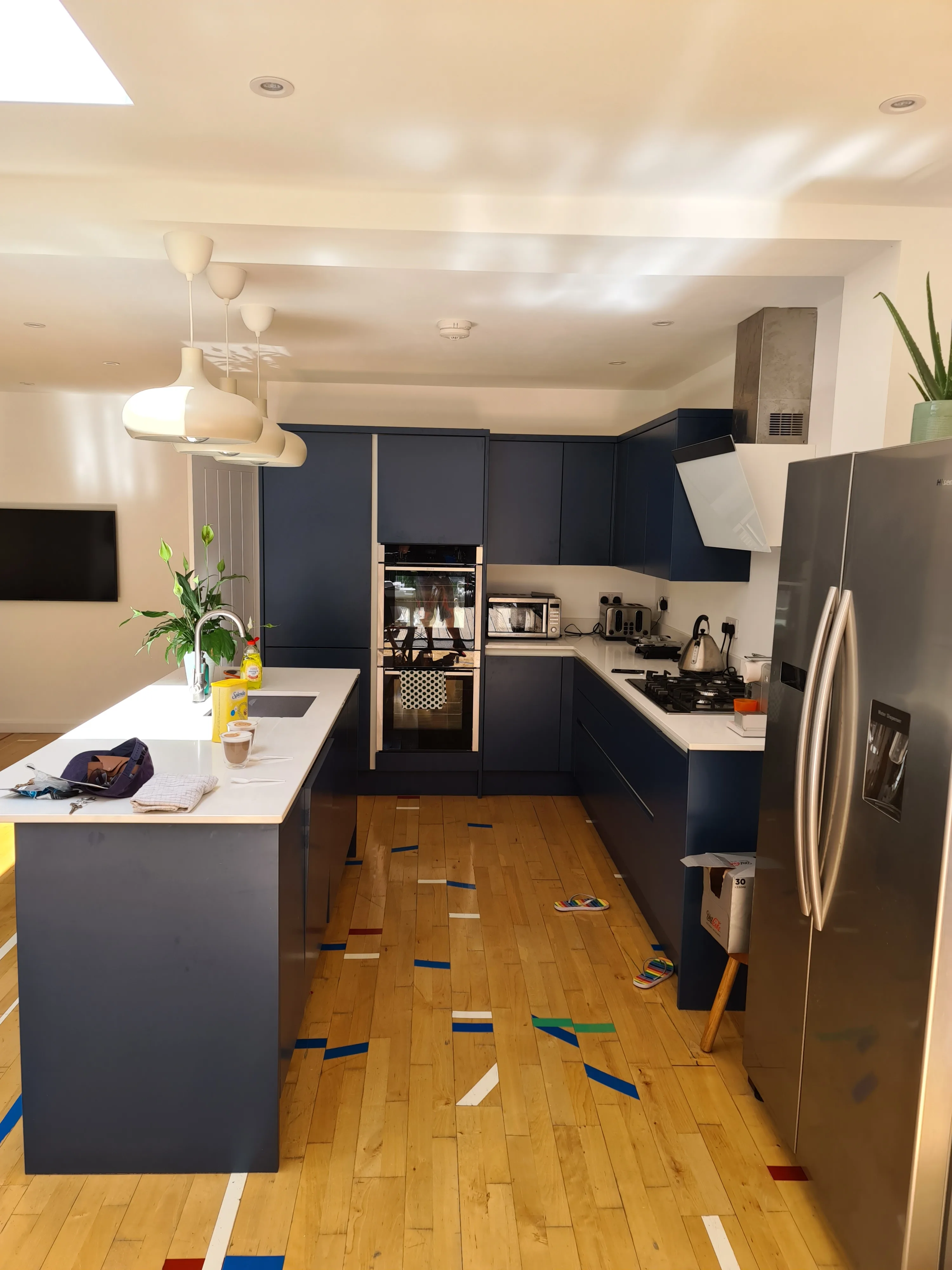 Modern kitchen refurbishment with sleek blue cabinetry and wooden flooring