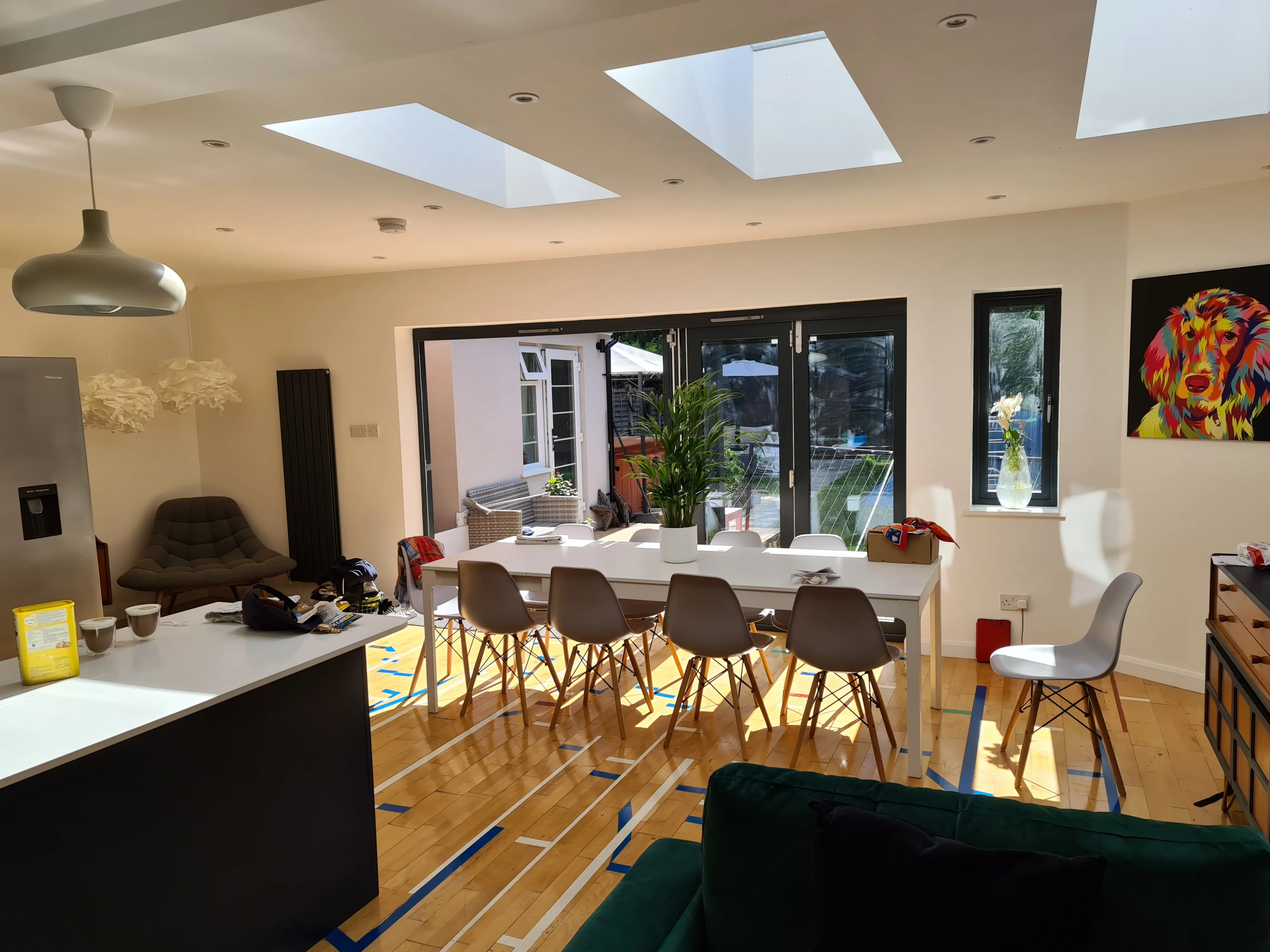 Modern kitchen and dining area with large windows and skylights, showcasing natural light and open space