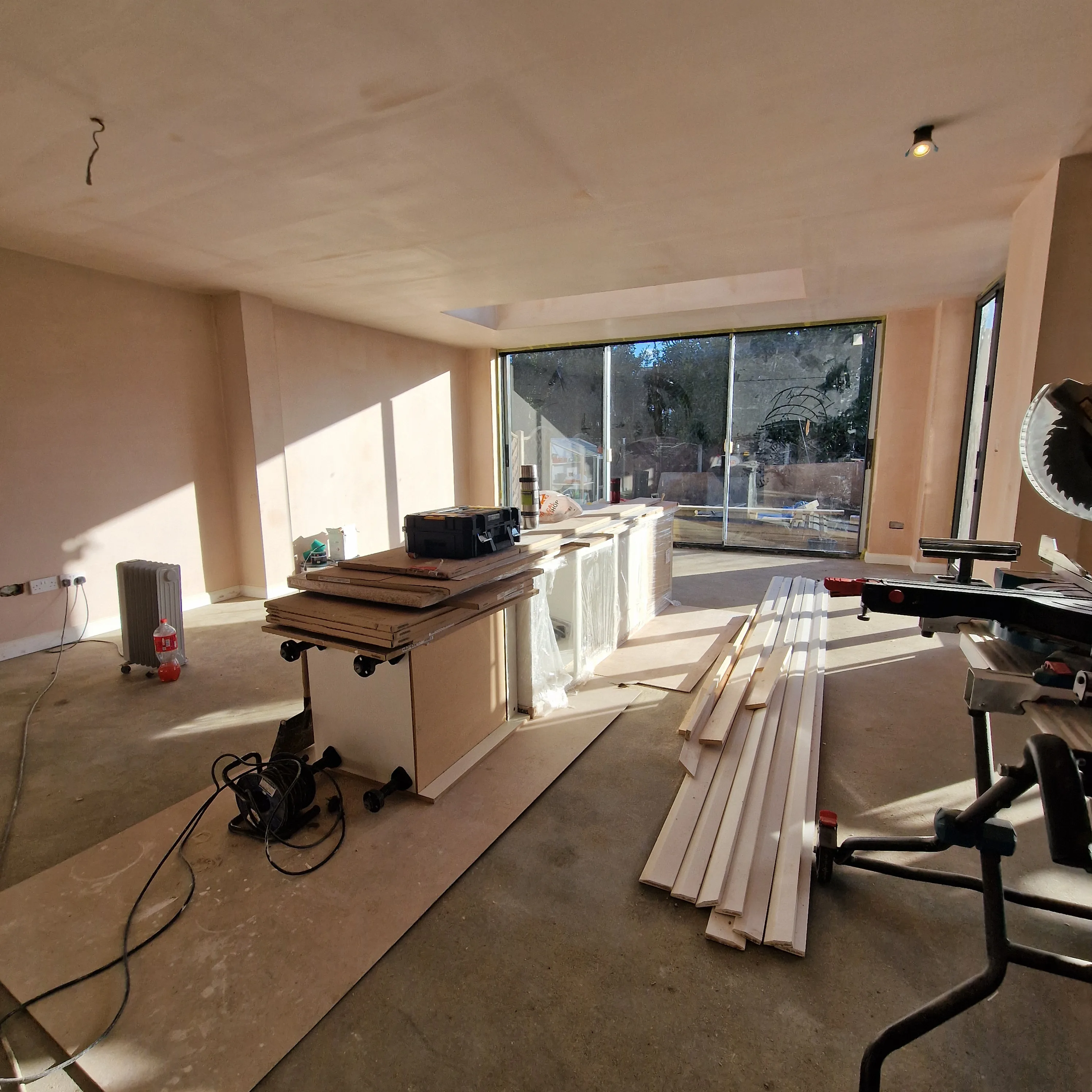 Interior view of a renovation site with wooden materials and tools visible