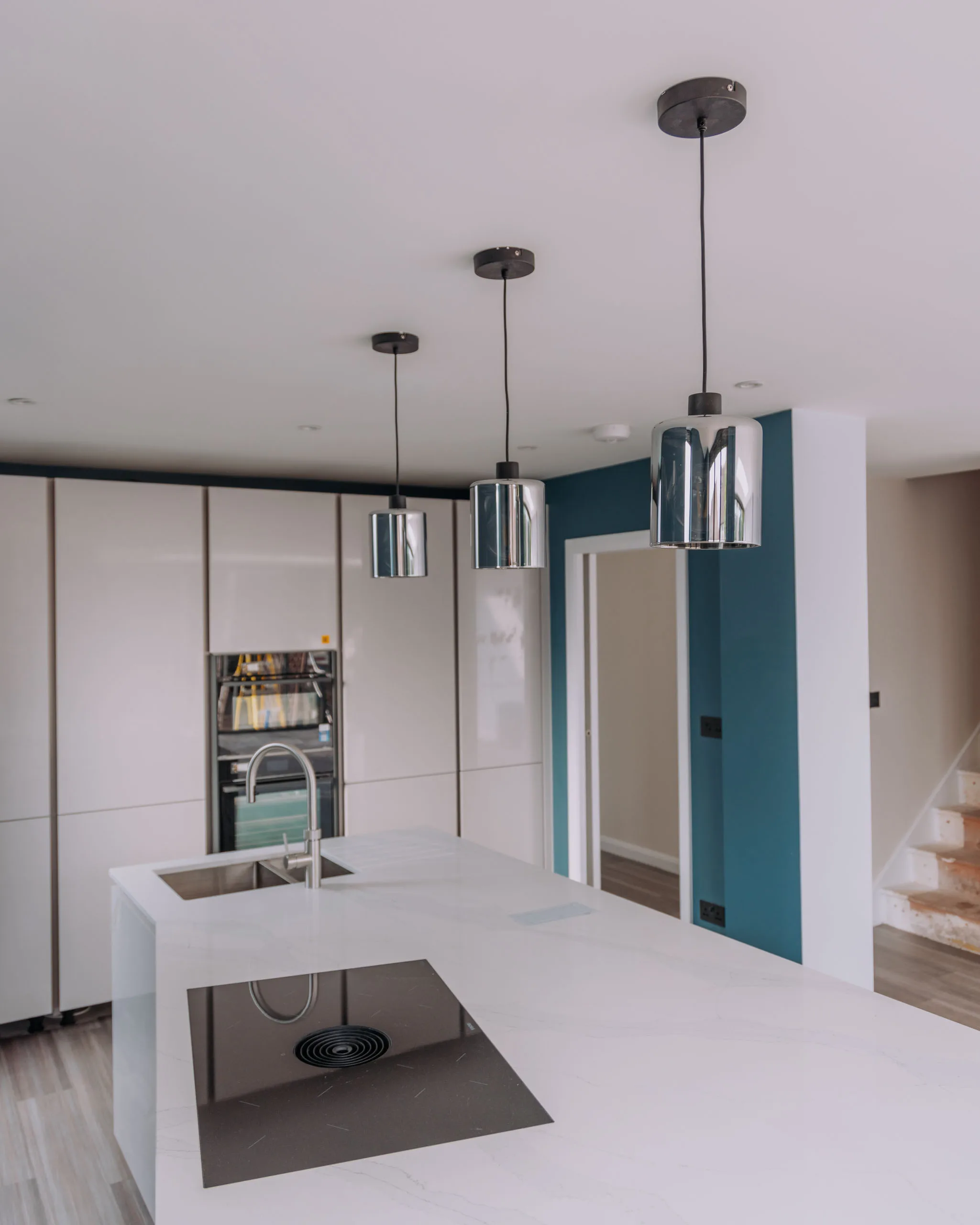 Modern kitchen interior featuring sleek cabinetry and pendant lighting