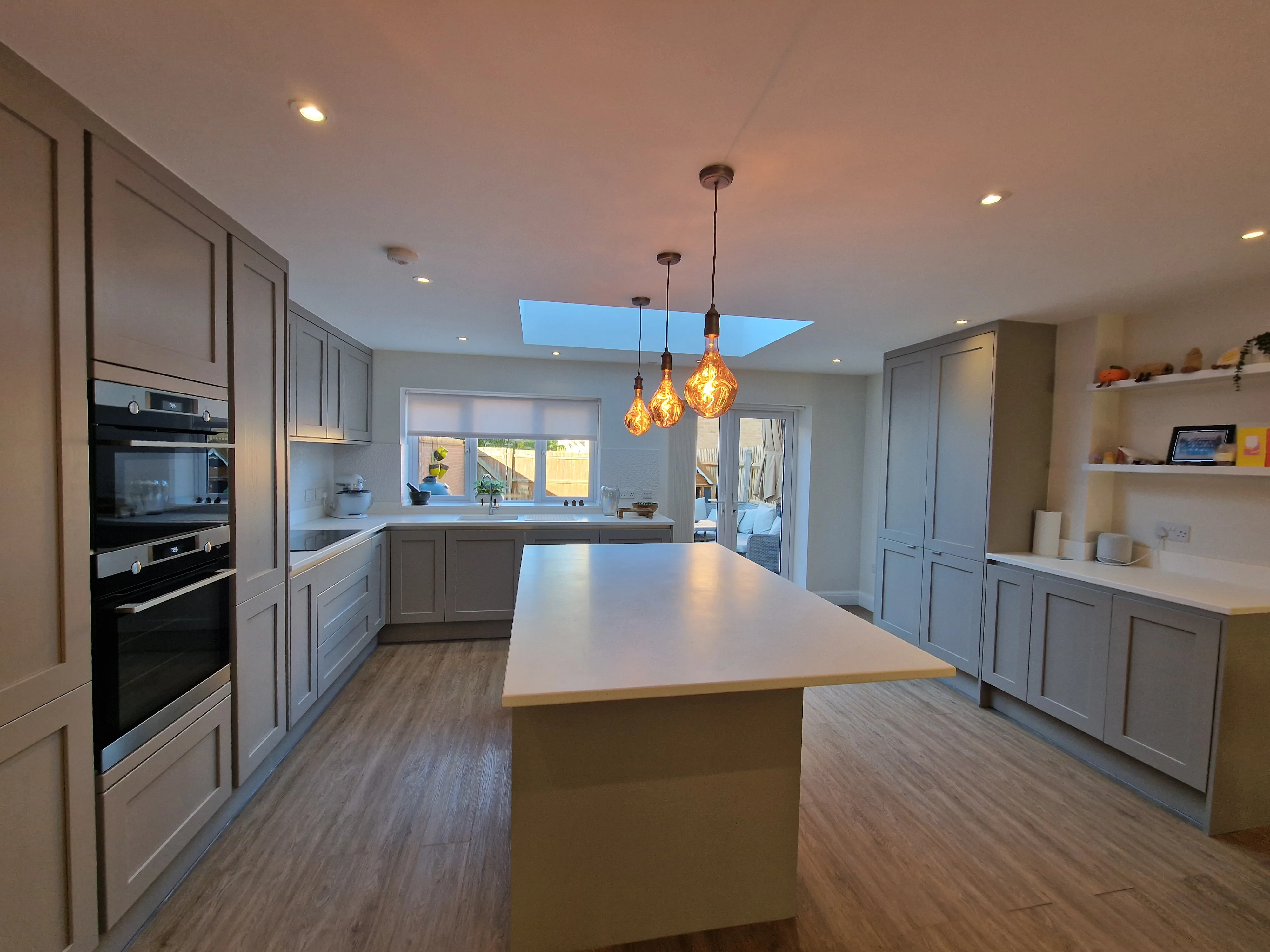 Modern kitchen refurbishment with sleek cabinetry, an island, and pendant lighting