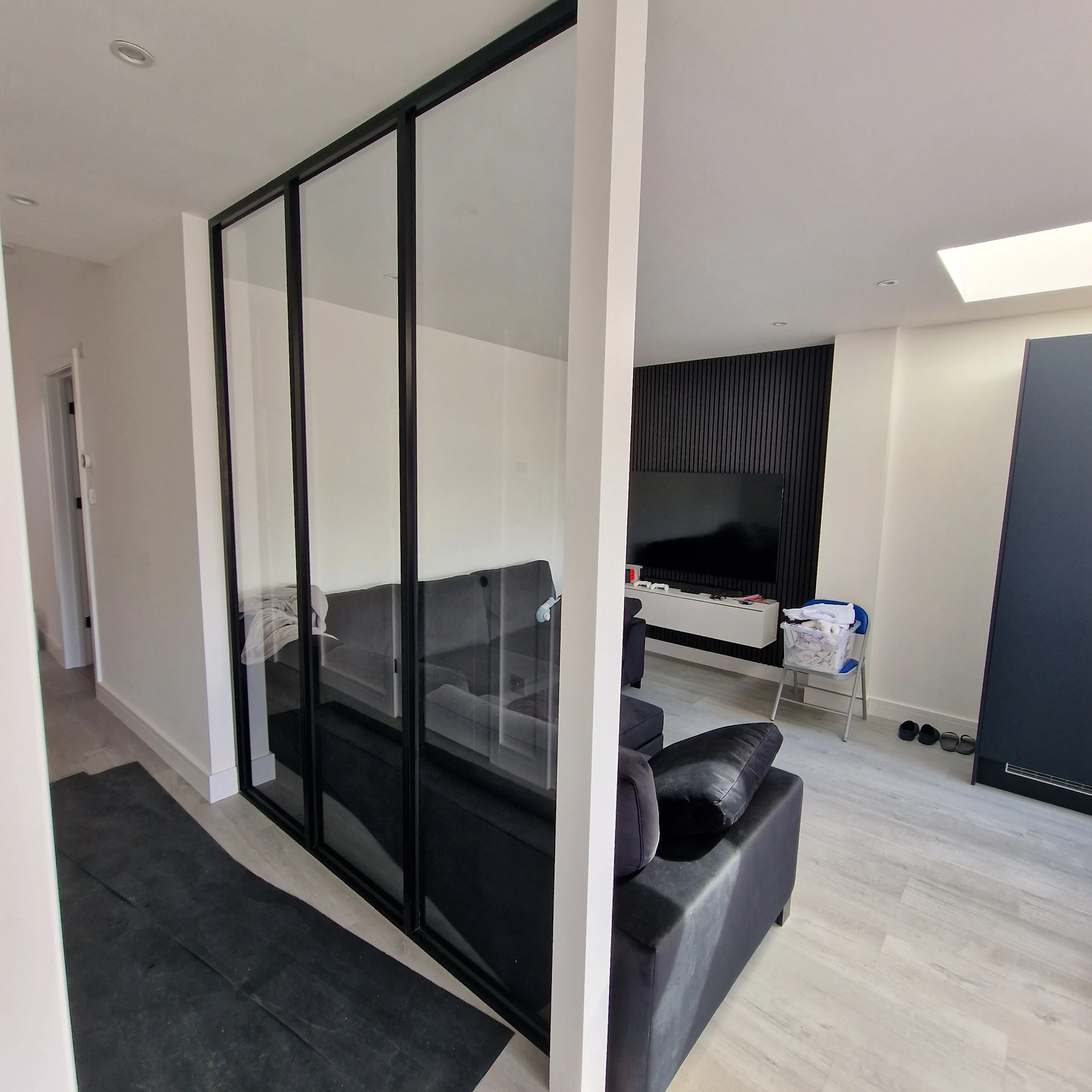 Modern living space featuring a glass partition and contemporary furniture