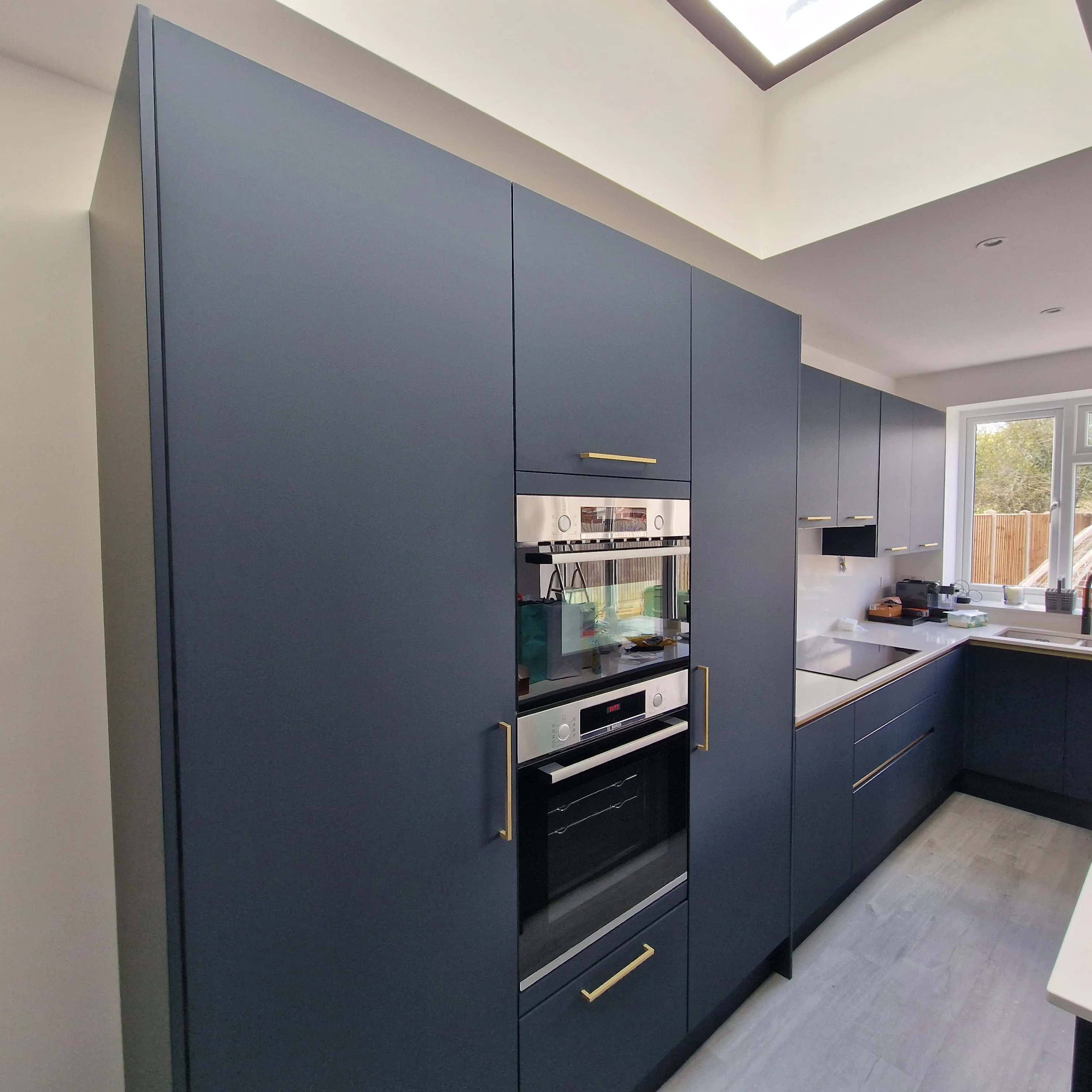 Modern kitchen cabinetry with built-in appliances and natural light from a skylight