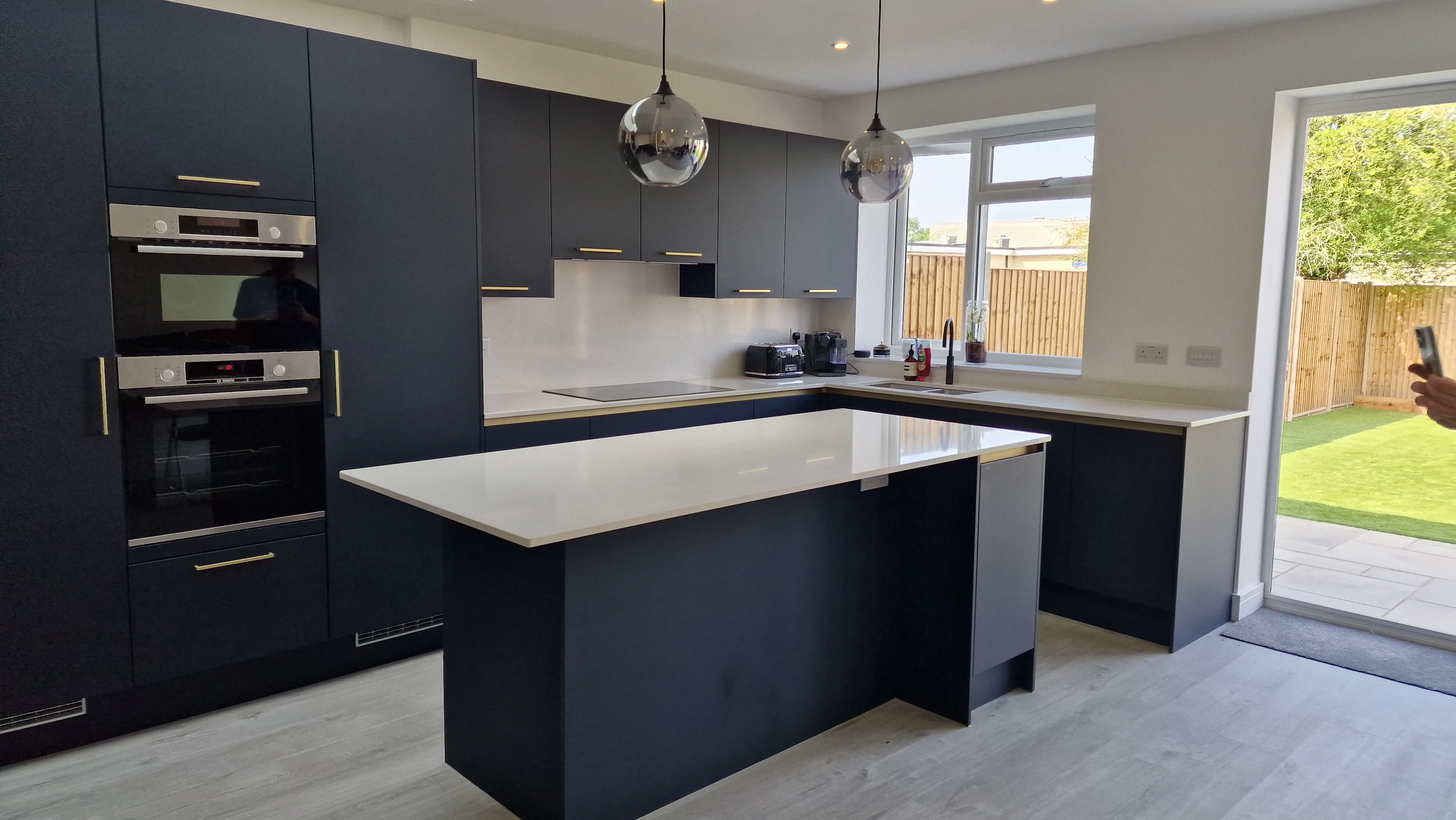 Modern kitchen refurbishment with dark cabinetry and an island countertop