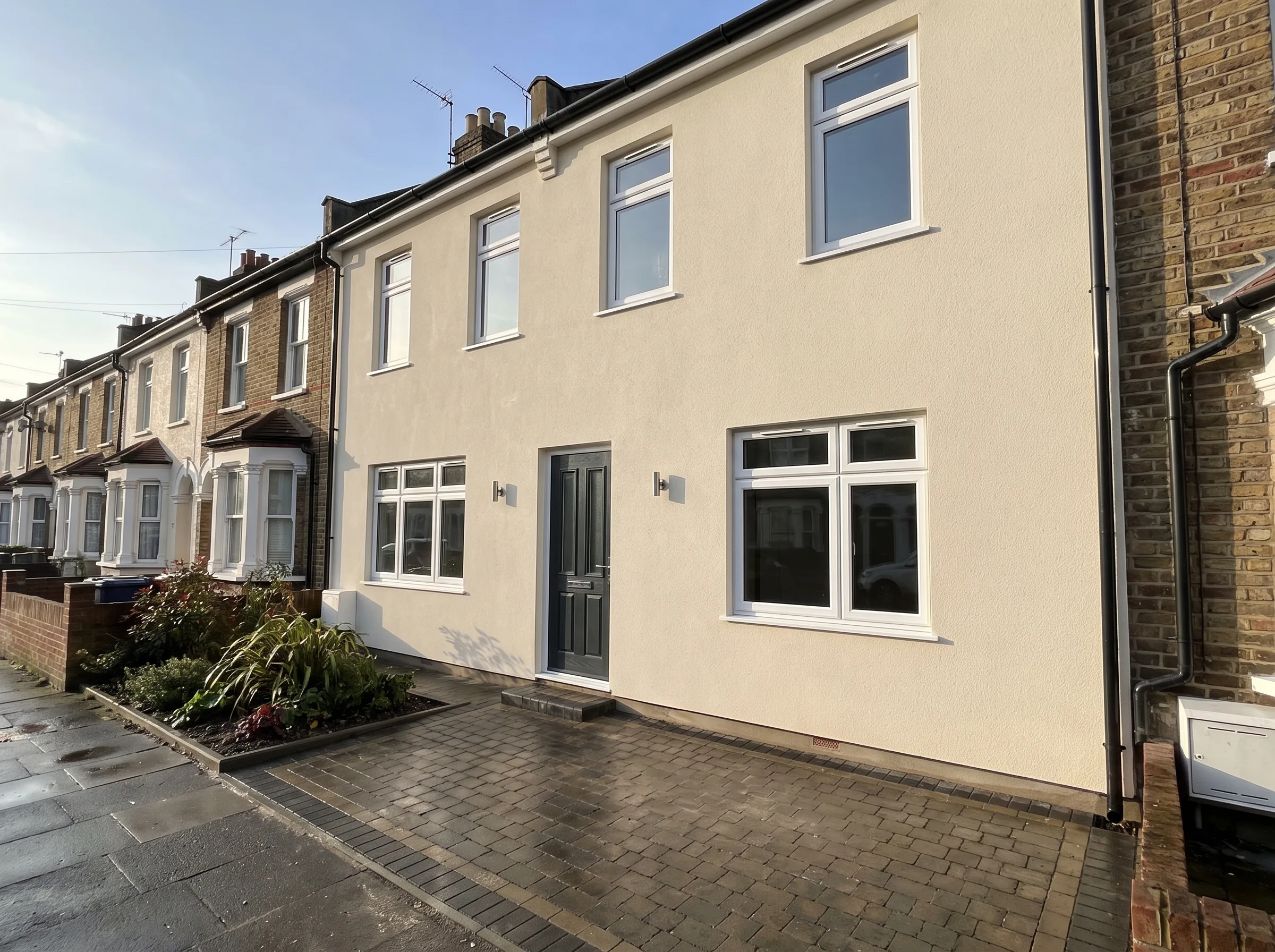 Newly rendered house exterior with a modern entrance and landscaped front space
