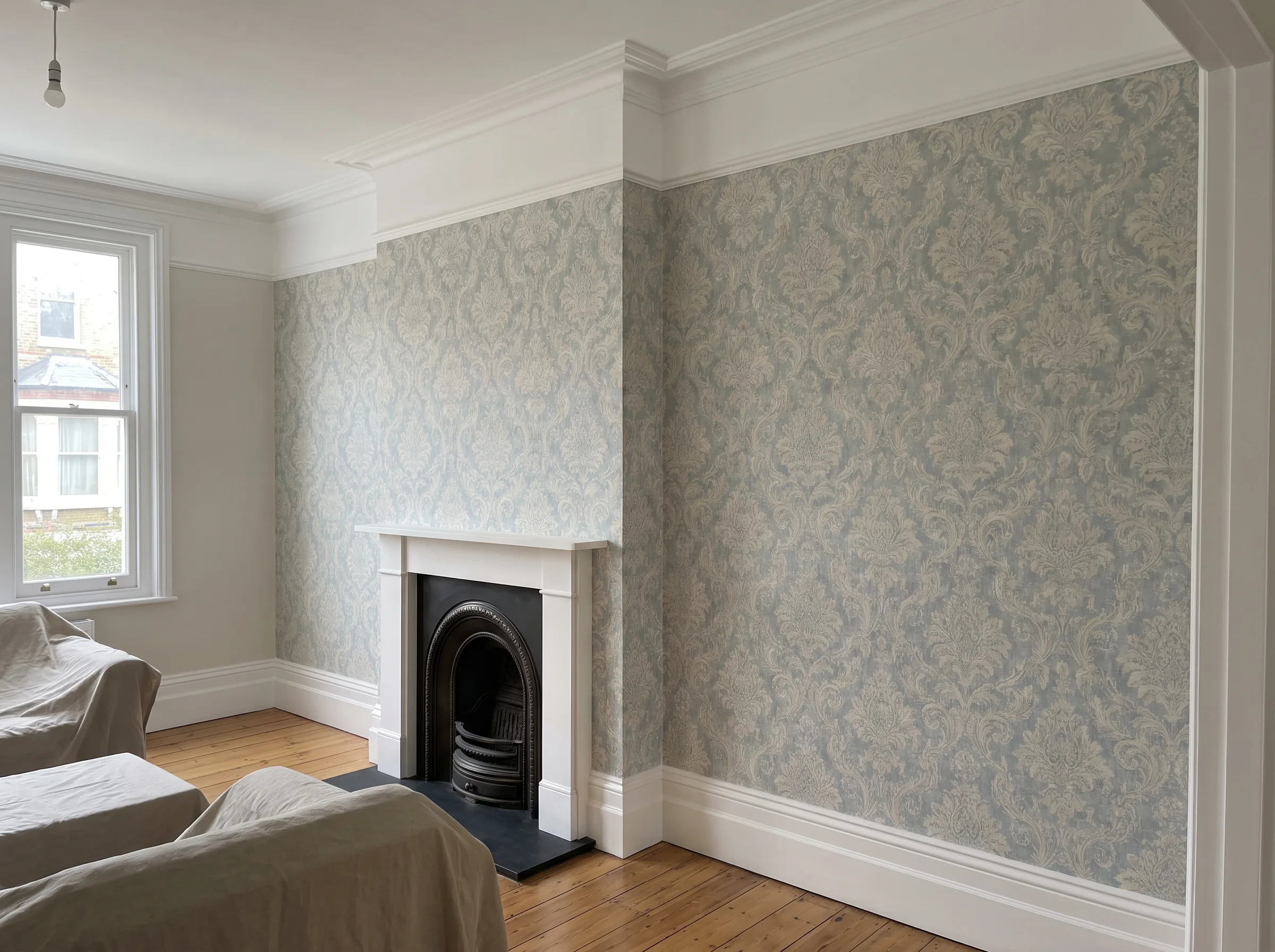 Renovated room with decorative wallpaper and a classic fireplace