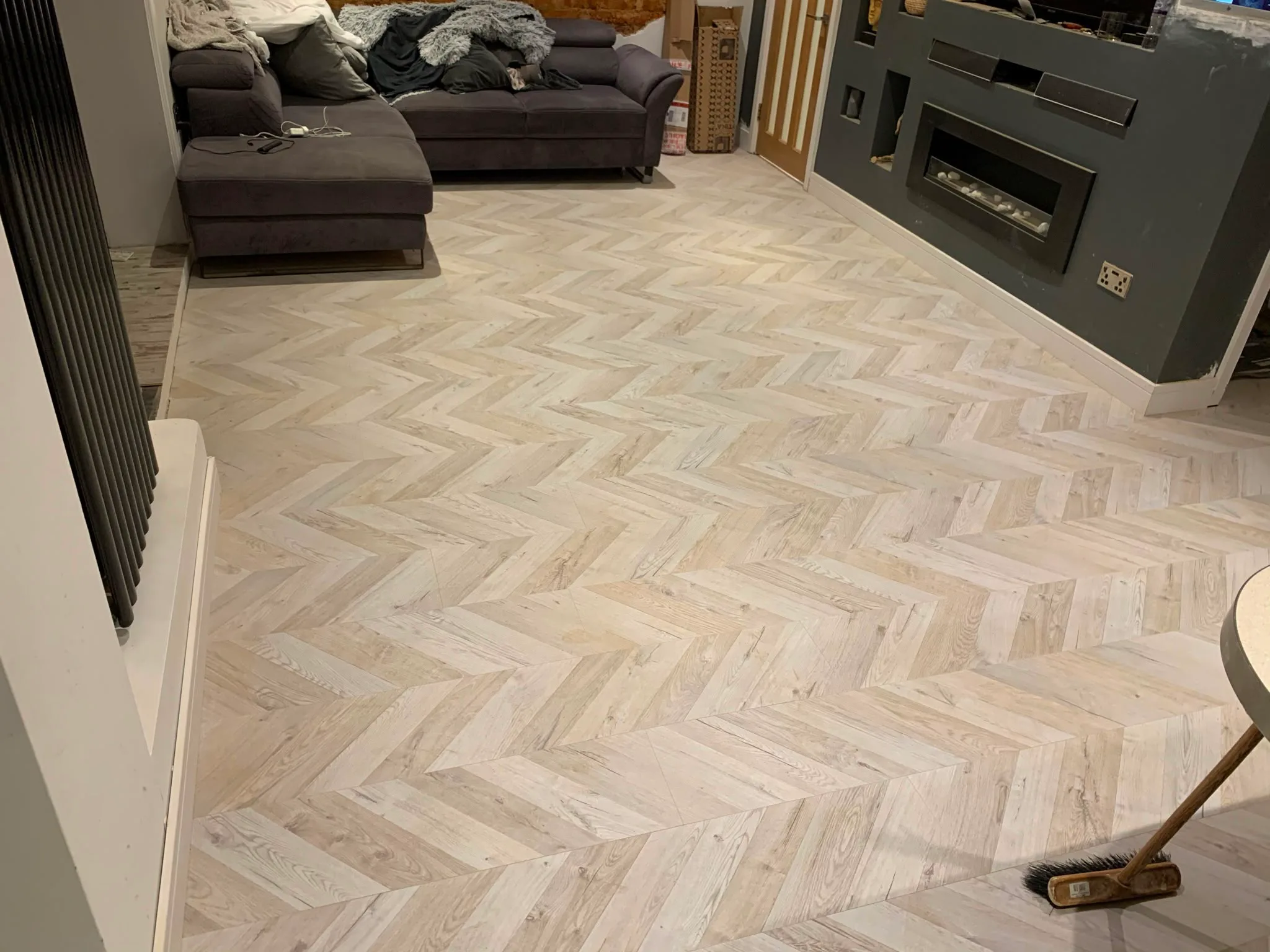 A newly installed herringbone wooden floor in a modern living room setting